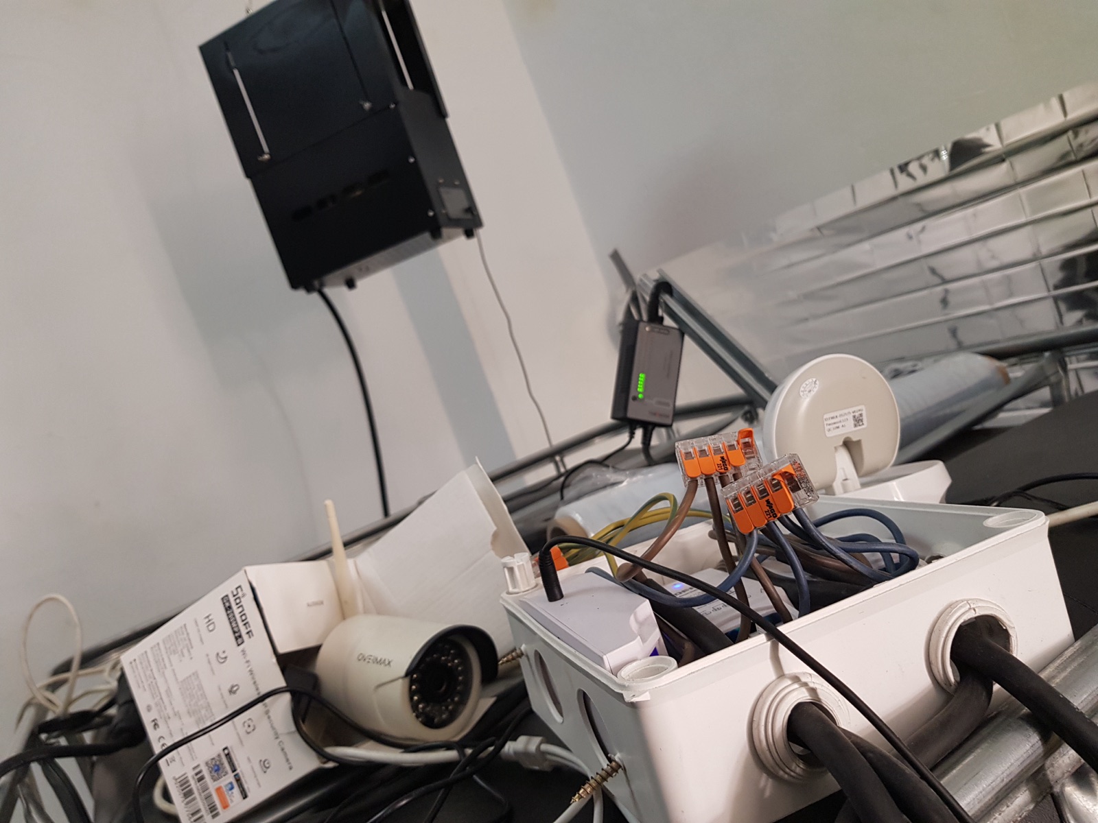Electrical infrastructure detail — Wago 221 connectors in junction box, PoE security camera, network switch